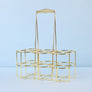 Gold metal bottle caddy with six slots.