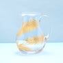 Glass pitcher with gold palms.